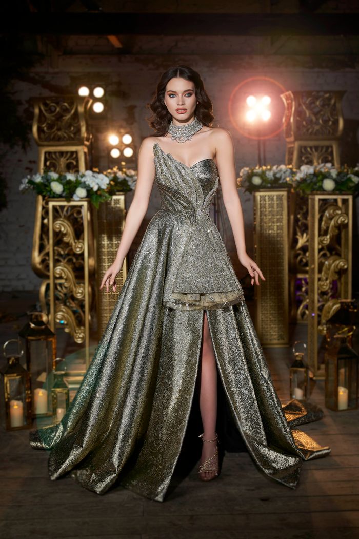 Stylish woman in a silver gown poses indoors at an elegant venue in İzmir, Türkiye.
